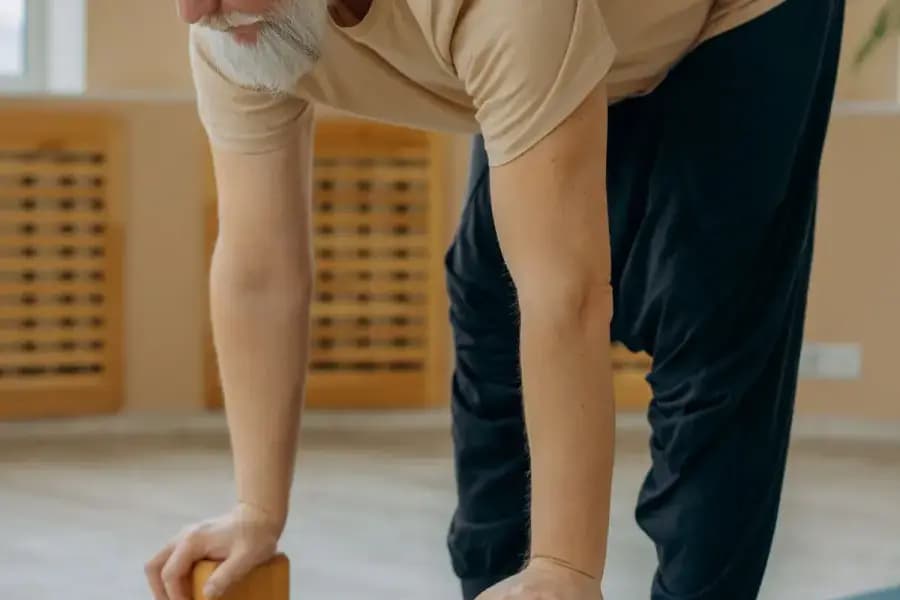 Elderly balance and fall prevention physiotherapy Bengaluru — senior citizen performing single-leg standing balance drill under the Otago exercise programme delivered at home by Pro Physiotherapy JP Nagar