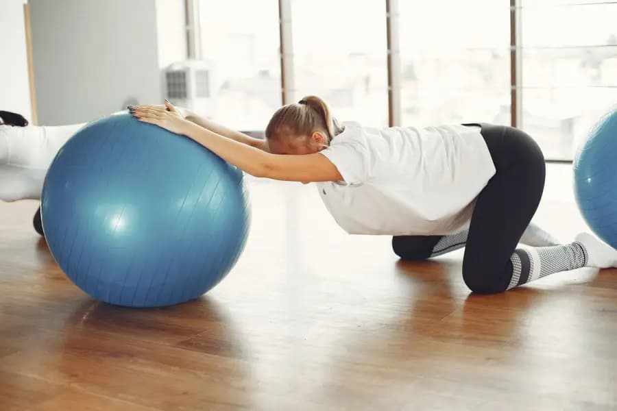 Prenatal postnatal back pain physiotherapy Bangalore — pregnant patient performing safe stability-ball back-pain exercise from the Mandara pregnancy programme delivered at home by Pro Physiotherapy JP Nagar